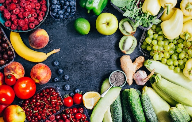 Vista dall'alto di verdure, frutta, bacche su sfondo nero con spazio libero per il testo