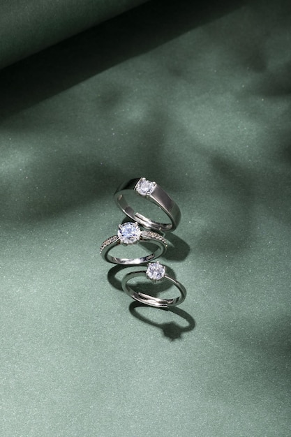 Top view vertical shot of diamond rings on a green background