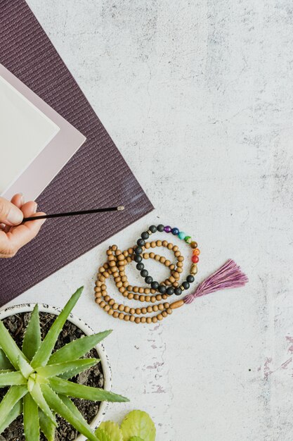 Top view of a violet yoga mat, bad wooden beads on white background. Essential accessories for practice yoga and meditation. Copy space