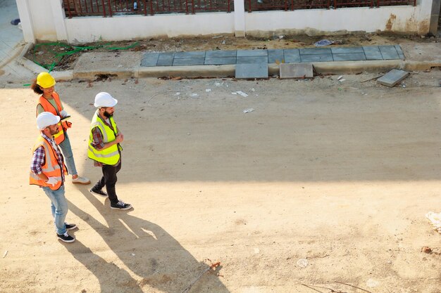 Top view walking Group professional confident Mechanical civil Engineer and construction team at house project underconstruction site Group portrait Unity and teamwork concept