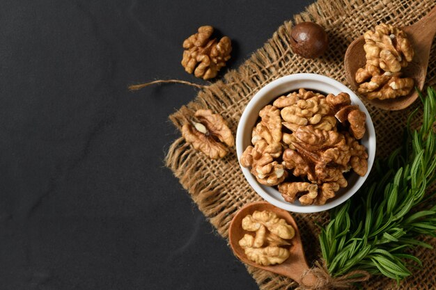 Photo top view of walnut in white cup on black background healthy nuts concept