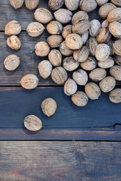 Top view on walnuts in their shell spread on a plank