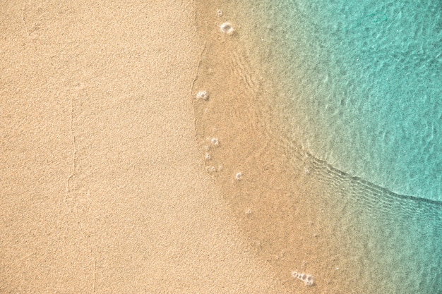 Photo top view of water touching sand at the beach