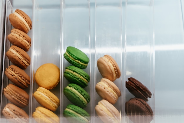 Top view on white box with pastel French macaroons 