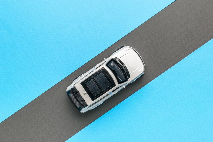Photo 青い背景の灰色の道路に沿って動く白い車のトップビュー オートマニアのコンセプト フラットレイ