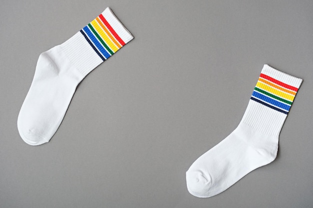 Top view white cotton socks with rainbow colors on grey background LGBTQ symbol gift idea to LGBT friends mockup