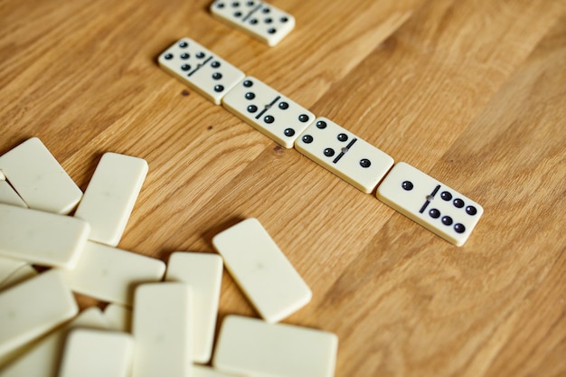 Foto vista dall'alto di giochi di domino bianchi su sfondo di tavolo in legno con concetto di gioco da tavolo spazio copia