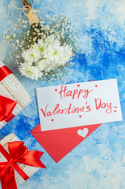 top view white flowers gifts happy valentines day written on letter red envelope on blue background