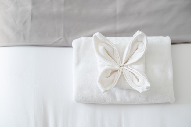 Top view of white fresh towel on bed