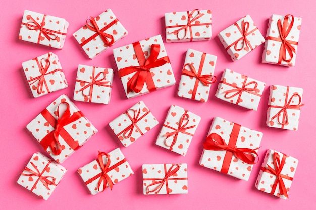 Top view of white gift boxes with hearts on pink