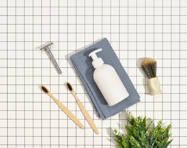 회색 수건 면도기 생태 칫솔에 있는 흰색 액체 비누 디스펜서의 상위 뷰 면도용 욕실 액세서리 제품의 구성