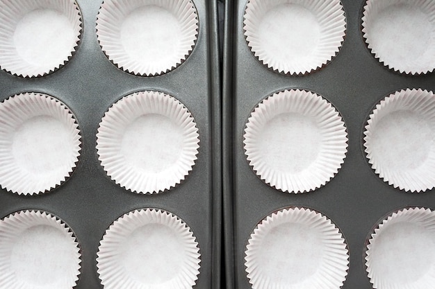 Top view of white paper wraps for muffins in baking dish