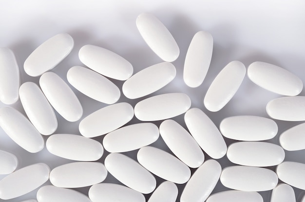 Top view of white pills on a white background