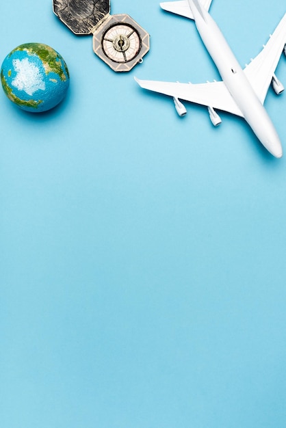 Top view of white plane model compass globe on blue background