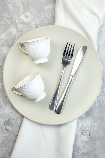 Vista dall'alto piatto bianco con tazze forchetta e coltello su sfondo chiaro cucina cibo vetro donna femminilità pasto orizzontale