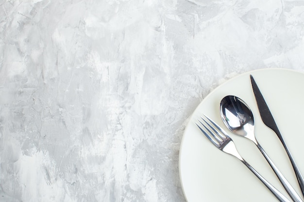 Top view white plate with cutlery inside on white surface colour kitchen food meal cuisine horizontal glass free space