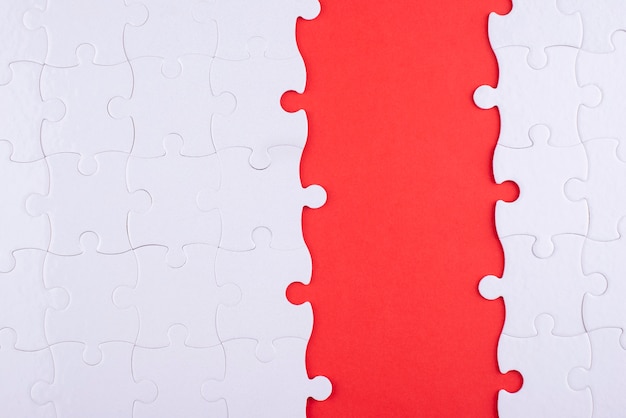 Pezzi di puzzle bianchi vista dall'alto e sfondo rosso