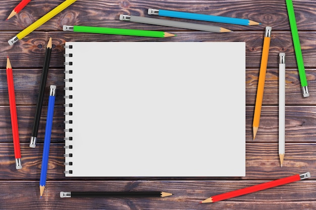 Вид сверху белой спиральной бумажной обложки Art Bbook с разноцветными карандашами на деревянном столе. 3d рендеринг