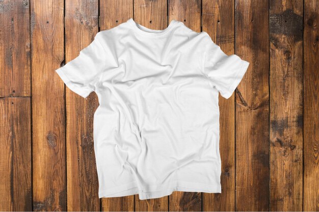 木製の背景に白いTシャツの上面図