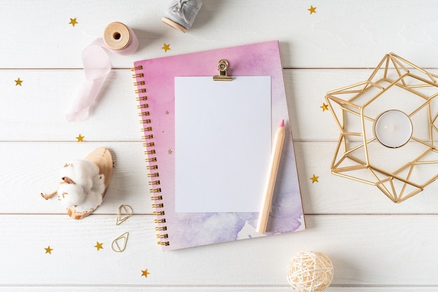 Top view of white working table background with blank paper notebook, nature cotton.