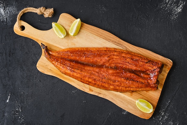 Top view of whole smoked eel on wooden cutting board