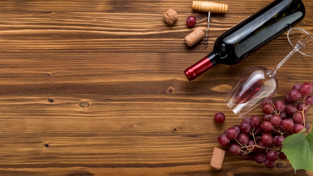 Top view wine bottle with glass on wooden background