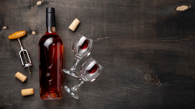 Бутылка вина сверху с бокалами и штопором рядом