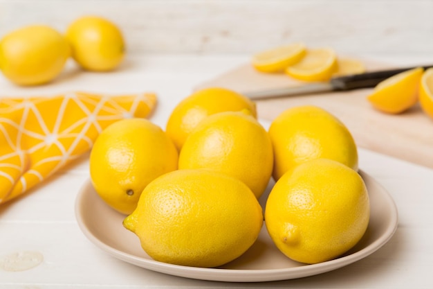 Top view with copy space for fresh and ripe lemons on cutting board healthy food background elegant background of lemon and lemon slices with squeezer and knife colored background