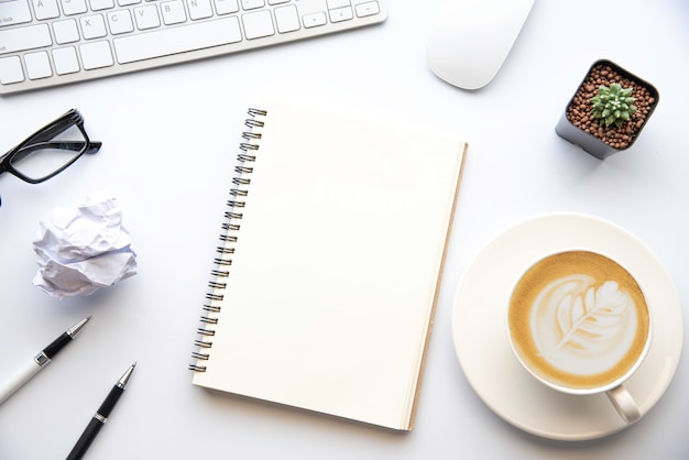 top view with copy space, working desk with laptop,cell phone,notebook pencil and coffee on white background
