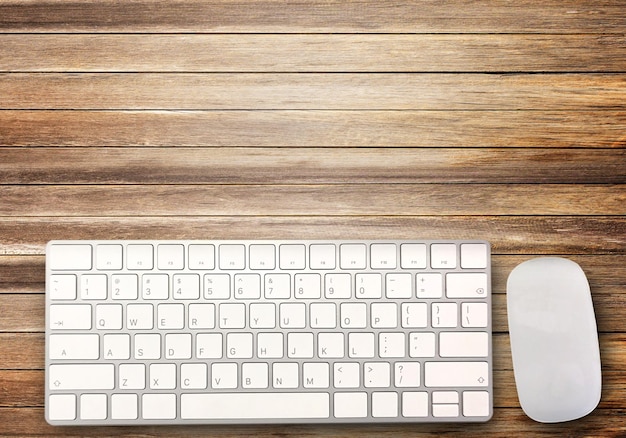 Top view with mini wireless keyboard and mouse on brown wood table background