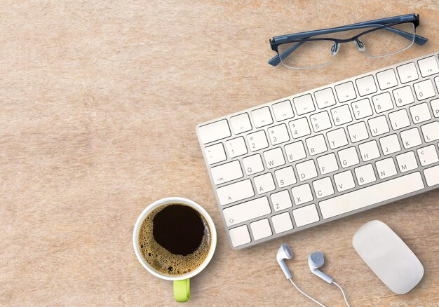 Top view with mini wireless keyboard and mouse with coffee and glasses on wood table