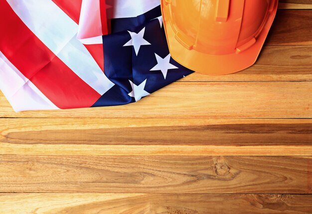 Top view with orange safety helmet and usa flag on wood table background