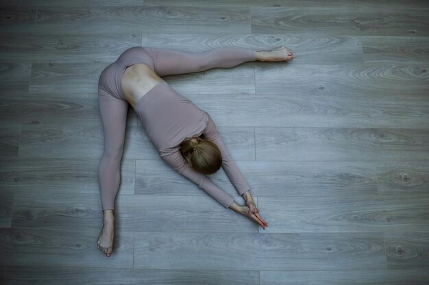 Top view of woman doing relaxation exercises on wooden\
floor