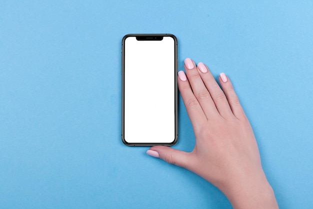 Vista dall'alto di una mano di donna che utilizza iphone su sfondo blu