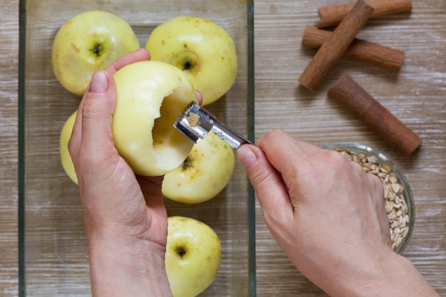 Top view of woman hands holding the special knife for taking away apple seeds