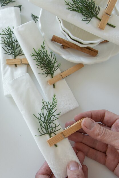 Top view of woman hands preparing and arranging the table for winter holidays. Winter decoration, DIY