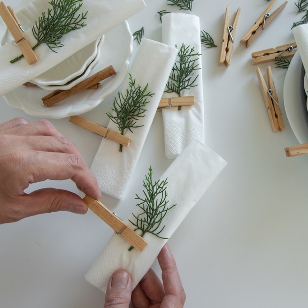 Top view of woman hands preparing and arranging the table for winter holidays. Winter decoration, DIY