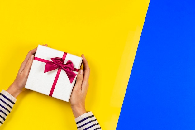 Top view to woman hands with gift present box