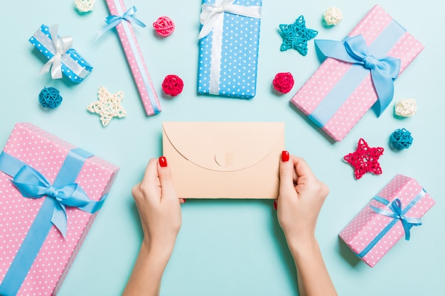 Top view of woman holding an envelope on blue background 