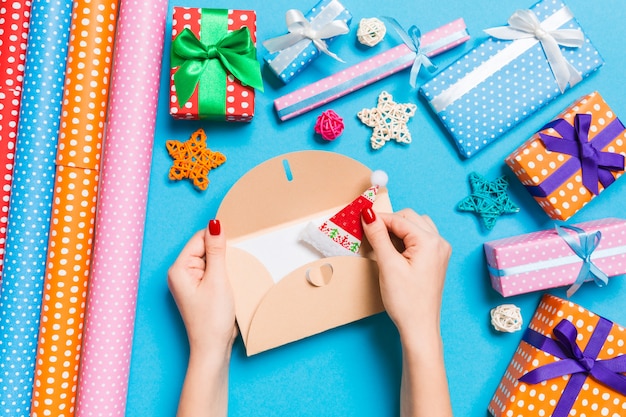 Top view of woman holding an envelope, holiday decorations. Christmas time concept