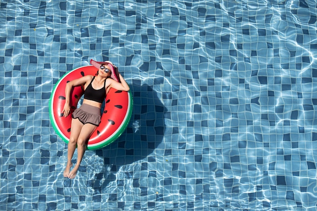 Top view of woman lay on balloon in pool