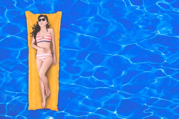 Photo top view of woman relaxing in a pool with copy space