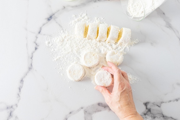 Top view of a woman's hand holding a freshly prepared curd the process of preparing a dessert marble white background