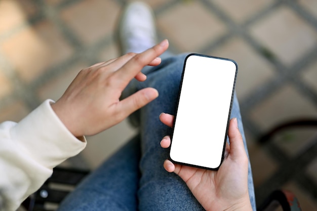 Top view of a woman using her smartphone at outdoor seating space smartphone mockup