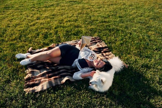 Top view Woman with her dog is having fun on the field at sunny daytime