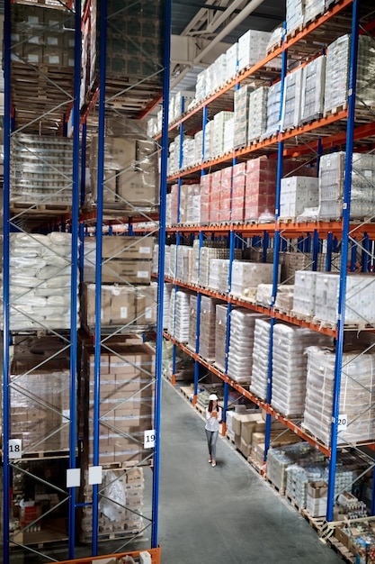 Top view of woman with tablet in large warehouse