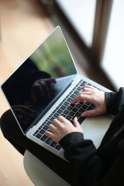 Top view woman worker using laptop keyboard at her workplace