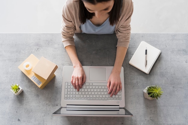 Top view of woman working at desk with laptop