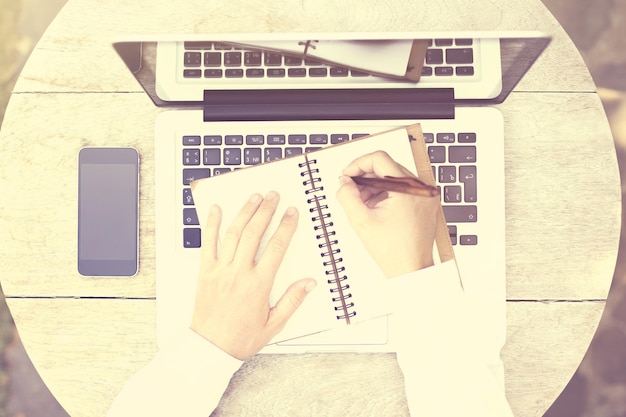 Top view of a woman writes notes in notepad