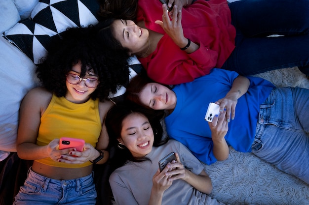 Foto donne vista dall'alto a letto con smartphone